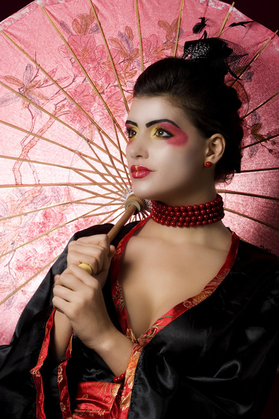 Sexy young geisha holding an umbrella - Fotografie, Obrázek