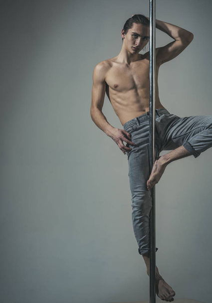 Sport and art concept. Athlete, sportsman performing pole dancing moves, - Foto, afbeelding