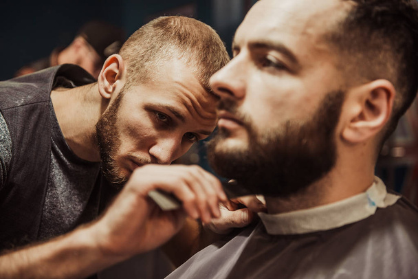 Friseurmeister schneidet Kunden den Bart. - Foto, Bild