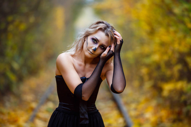 Een vrouw is het dragen van skelet make-up op haar gezicht voor een Halloween-viering of kostuum idea.outdoor. Schoonheid uit de hel, spooky vrouwelijke portret, - Foto, afbeelding