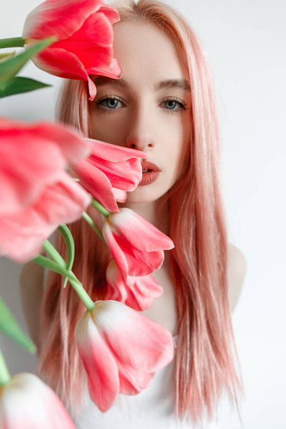 Portrait of a girl with pink hair pink spring flowers - Фото, зображення