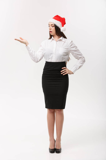 Business Concept - Moderní kavkazská podnikatelka v bílém ateliéru pozadí držící ruku na straně prezentující produkt. - Fotografie, Obrázek