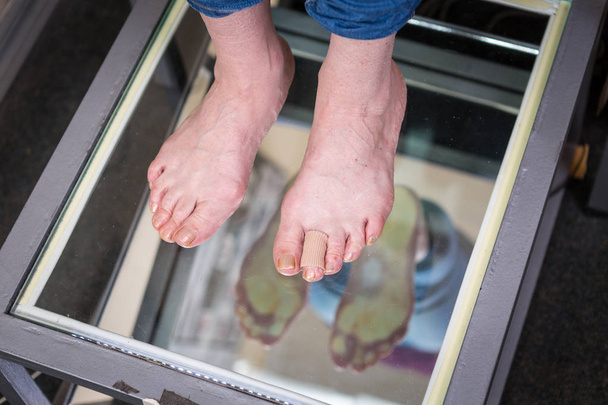 Крок цифрове сканування ніг, сканування ніг для нестандартних взуттєвих імплантатів, позування та аналіз рівноваги. Доктор, пацієнт
 - Фото, зображення