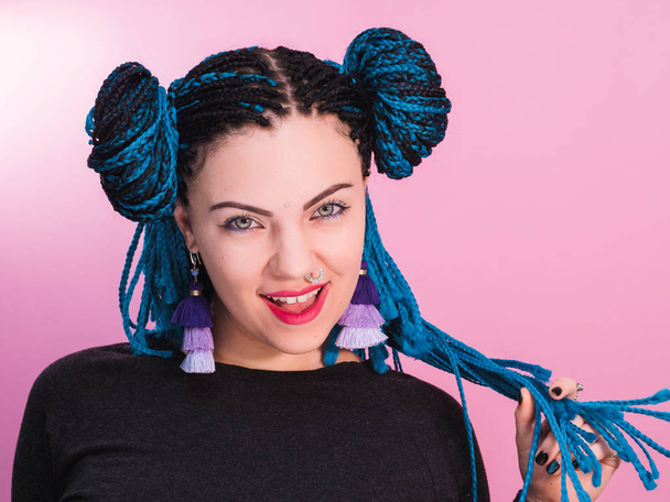 Glamour playful portrait of sexy woman with african blue braids hairstyle, bindi, nose ring and tassel earrings isolated on colorful background. - Φωτογραφία, εικόνα