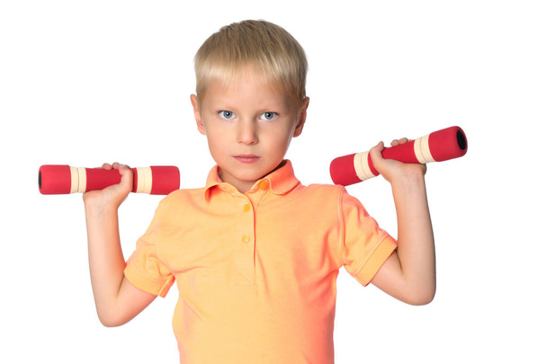 A little boy is lifting dumbbells. - Foto, Imagen