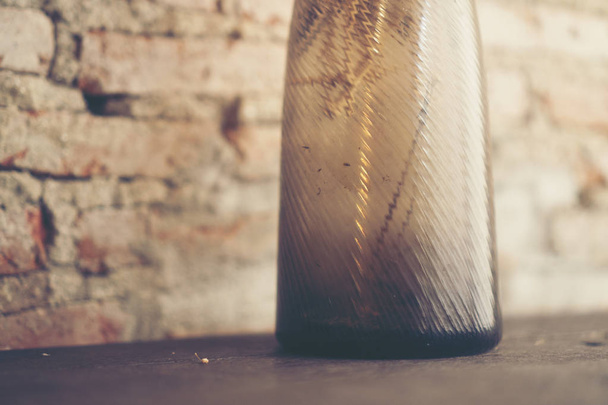 Старая бутылка на столе  - Фото, изображение