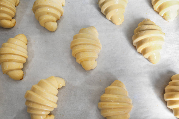 Tray with uncooked sweet croissants in bakery - Foto, imagen