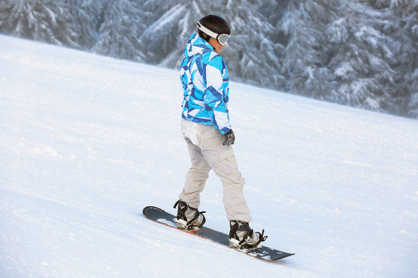 Snowboarder on ski piste at snowy resort. Winter vacation - Фото, изображение