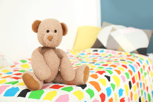 Toy bear on bed in childrens room - Fotoğraf, Görsel