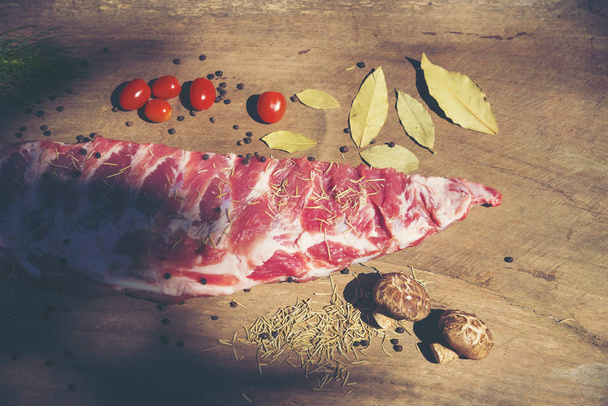 Raw ribs with a rosemary and vegetables. on crumpled paper - Foto, afbeelding