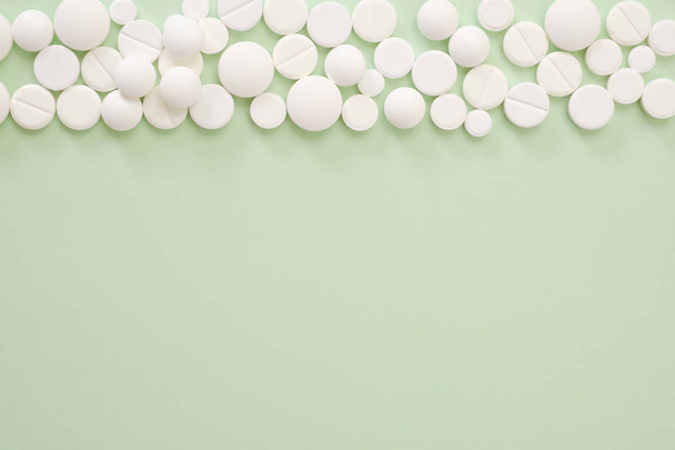 Heap of white pills on green background - Fotoğraf, Görsel
