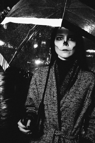 hallowen make up. girl with umbrella on the street in evening  - Valokuva, kuva