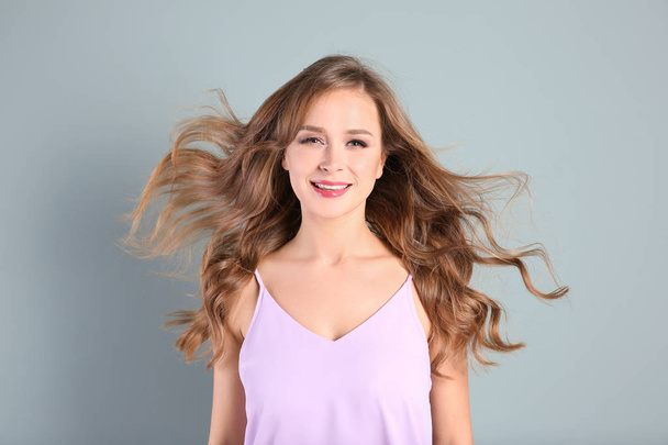 Portrait of young woman with long beautiful hair on light background - Photo, image