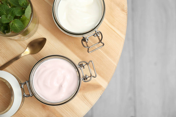 Frascos con diferentes yogures en la mesa
 - Foto, Imagen