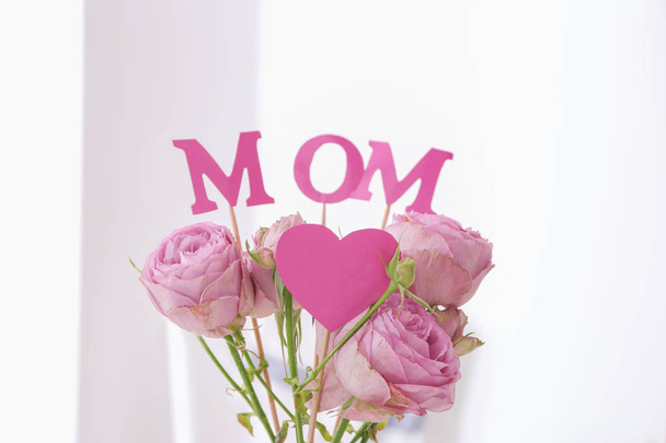 Beautiful bouquet with word MOM on light background. Mother's day celebration - Photo, Image
