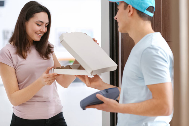 Young woman receiving order from courier. Food delivery service - Zdjęcie, obraz