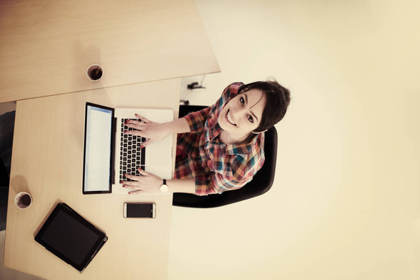 top view of young business woman working on laptop computer in modern office interior - Fotoğraf, Görsel
