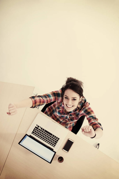 top view of young business woman working on laptop computer in modern office interior - Foto, imagen