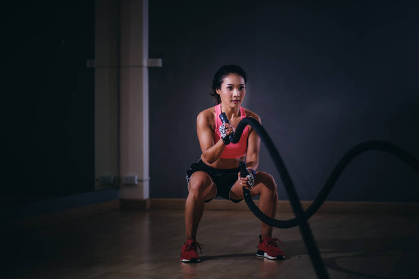 Ásia mulheres exercitando com cordas de batalha no ginásio
. - Foto, Imagem