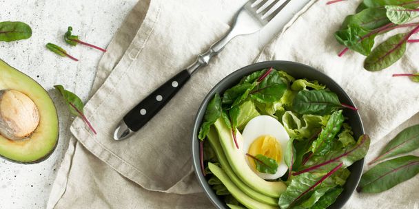Healthy vegan food. Bowl with salad, avocado and egg, top view. Diet food concept. - Foto, immagini