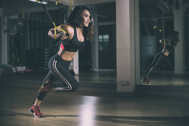 Strong woman doing trx exercise with straps in the fitness gym. - Fotoğraf, Görsel