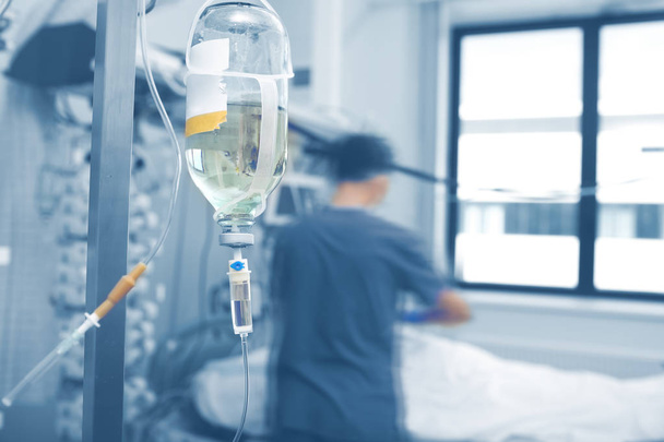 Intravenous infusion bottle hanging on the pole agienst the blur - Foto, immagini