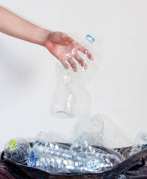 Πλαστικά μπουκάλια σε μαύρες σακούλες σκουπιδιών που περιμένουν να μεταφερθούν για ανακύκλωση. - Φωτογραφία, εικόνα