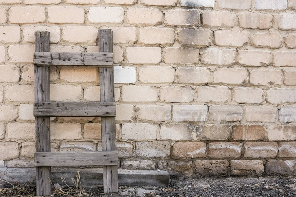 Деревянная лестница стоит у кирпичной стены
 - Фото, изображение