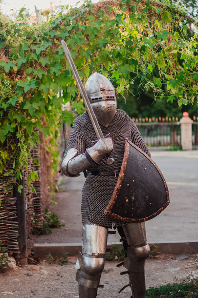 銃、厳しい表情の男。城に鎧の騎士。中世の写真イラスト。Batsenet ヘルメット、シールドとの戦いで剣を持つ騎士. - 写真・画像