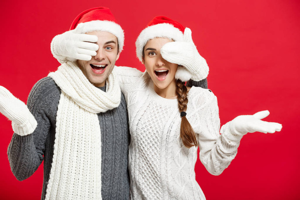 Christmas Concept - Young happy stylish couple in winter clothes close eyes each others celebrating in Christmas day - Zdjęcie, obraz
