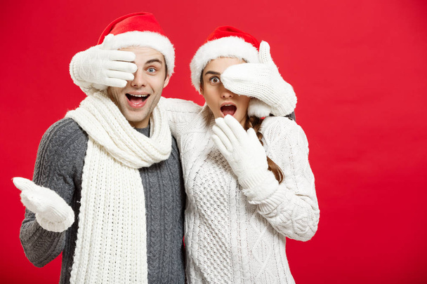 Έννοια Χριστούγεννα - ευτυχισμένος κομψό ζευγάρι σε χειμωνιάτικα ρούχα κλείστε τα μάτια κάθε άλλοι τον εορτασμό για την ημέρα των Χριστουγέννων - Φωτογραφία, εικόνα