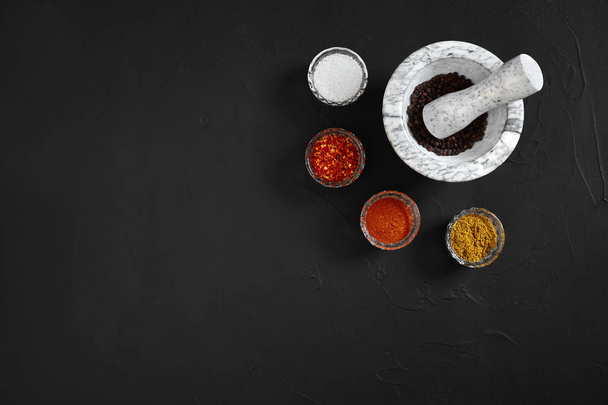 Various spices and mortar on black background with copy space - Photo, Image