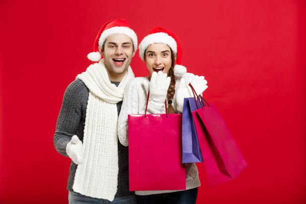 Kerst Concept - jong aantrekkelijk koppel houden boodschappentas genieten van winkelen en vieren in Kerstdag - Foto, afbeelding