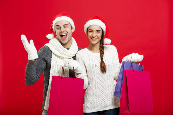 Concepto de Navidad - Joven pareja atractiva sosteniendo bolsa de compras disfrutar de compras y celebrar en el día de Navidad
 - Foto, imagen