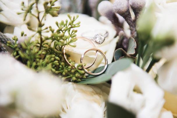 Wedding engagement rings and flowers wedding bouquet background, - 写真・画像