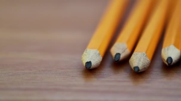 木製のテーブルの上の鉛筆の行のパン ショット - 映像、動画