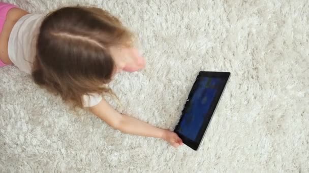 Μικρό κορίτσι δείχνει στην ψηφιακή οθόνη, που παίζει το παιχνίδι στο tablet pc. Παιδική ηλικία και την τεχνολογία. - Πλάνα, βίντεο