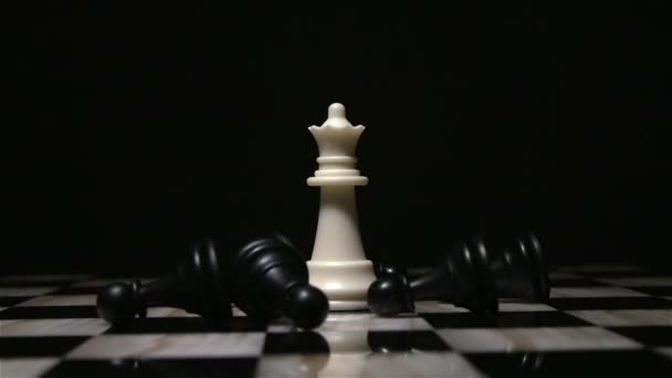 white queen piece surrounded by fallen black pawns - Footage, Video
