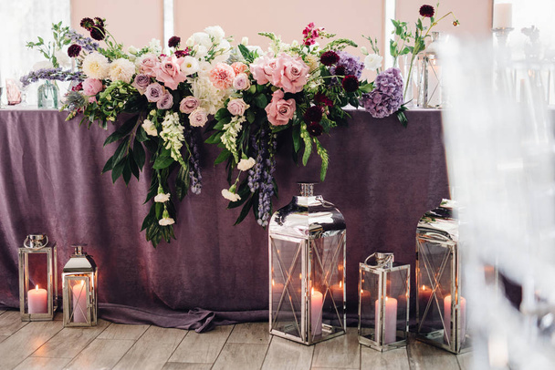 Stůl pokrytý fialové látky, květiny a svíčky pro svatební hostiny - Fotografie, Obrázek