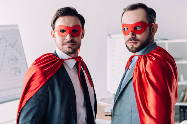 portrait of handsome super businessmen in masks and capes in office - 写真・画像