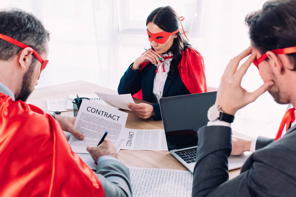 super uomini d'affari in maschera e mantelli al brainstorming in ufficio
 - Foto, immagini