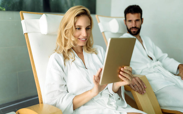 Beautiful woman relaxing and using digital tablet in spa - Photo, Image