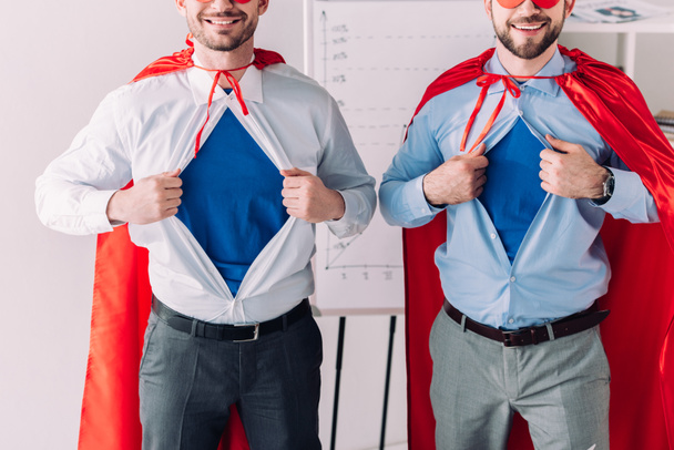 cropped image of super businessmen in masks and capes showing blue shirts in office - Photo, Image