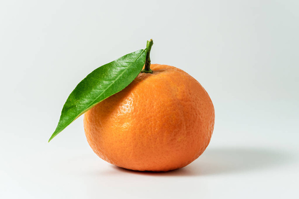Mandarine or clementine with green leaf  - Фото, изображение