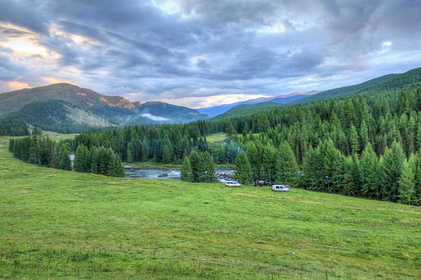 Viaje de ruta. Un campamento cerca del río sobre el telón de fondo de las montañas y la naturaleza salvaje de Altai
 - Foto, Imagen
