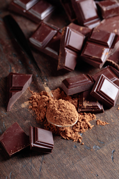 Broken  chocolate pieces and cocoa powder . - Foto, Imagem