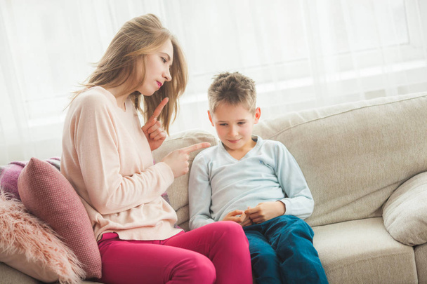 Mother punishing son on couch at home - Photo, Image