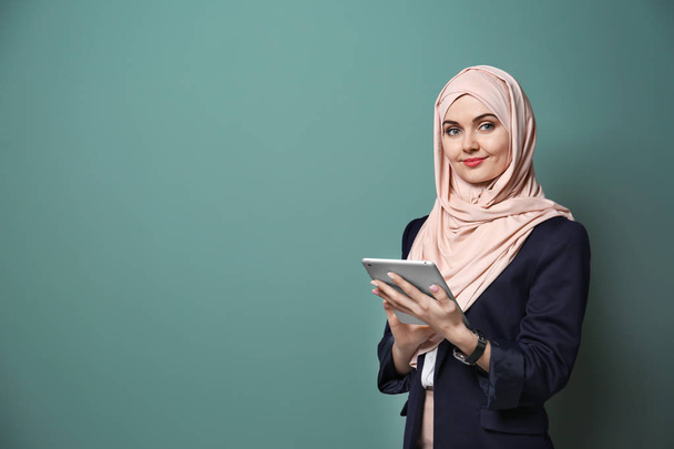 Muslim businesswoman in traditional clothes on color background - Foto, afbeelding