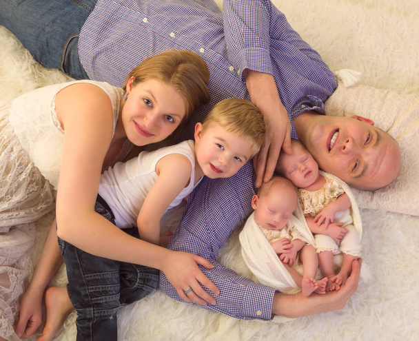 Familia sonriente con gemelos recién nacidos
 - Foto, imagen