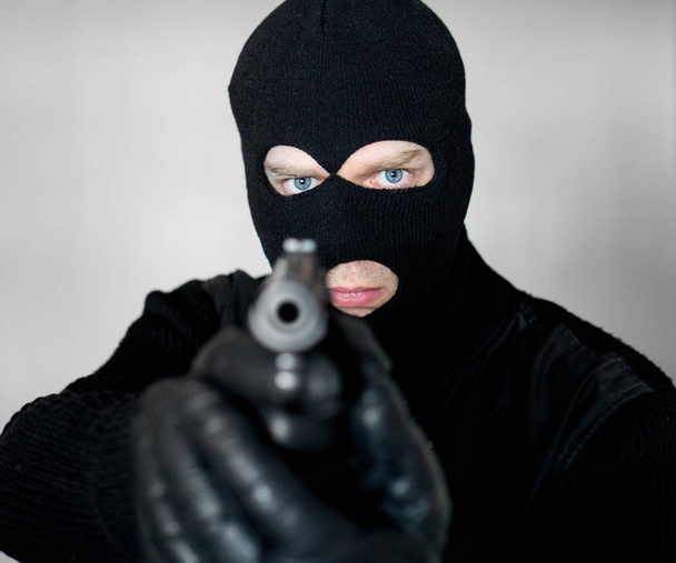 Porträt eines bewaffneten Mannes mit Sturmhaube. - Foto, Bild